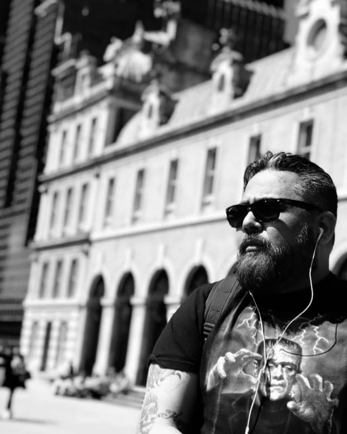 Edgar Calaveras wearing sunglasses in a black-and-white street portrait